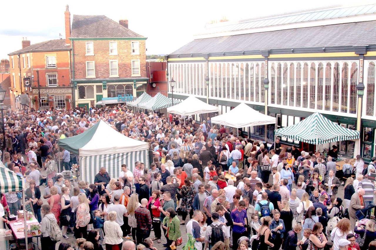 a crowd of people at Stockport Market place enjoying food stalls