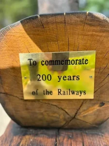 plaque on the end of a wooden sculpture